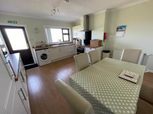 a kitchen and dining room with a table and chairs at Self Catering house with lovely sea views, 44 Back in Vatsker