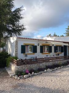 ein weißes Haus mit grünen Rollläden drauf in der Unterkunft Quinta das Hortênsias I Quinta do Sol in Cruz do Campo