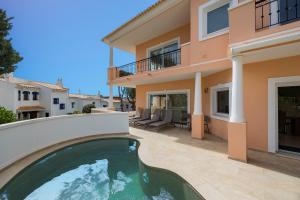 a villa with a swimming pool in front of a house at Vale Do Lobo Resort in Vale do Lobo