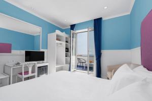 1 dormitorio con 1 cama grande y TV en Hotel Bougainville en Positano