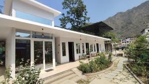 a white house with glass doors and plants at Indian Culture in Rishīkesh