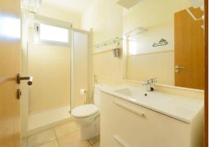 W łazience znajduje się toaleta, umywalka i lustro. w obiekcie Ático Apartamento Las Burras Playa w mieście San Agustin