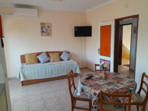 a living room with a bed and a table and a table and chairs at Residence 1000 Roses in Moncarapacho