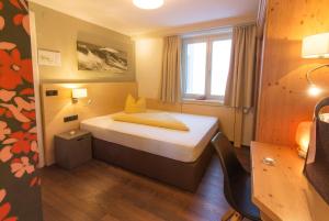 1 dormitorio pequeño con 1 cama en una habitación en Wohlfühlhotel Hubertushof, en Stuben am Arlberg