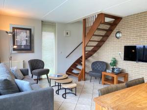 Una sala de estar con un sofá y una escalera. en Previnaireweg 20, en Callantsoog