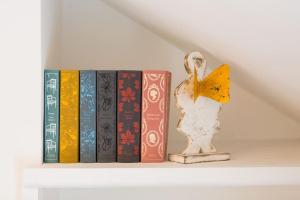 a row of books on a shelf with a figurine at Welcome to Port Isaac - Padstow - Polzeath in Saint Teath