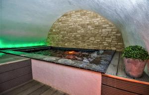 an outdoor hot tub with a fireplace in a room at La Maison de Sofia in Vallabrix