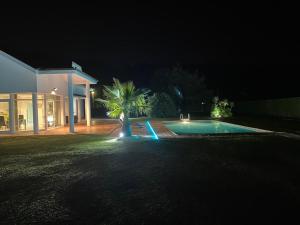 a swimming pool in front of a house at night at Villa LA PERLA con piscina privada in Parbayón