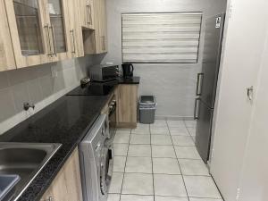 a small kitchen with a sink and a refrigerator at Luxury and Comfort Hideaway 2 - Solar Powered in Pretoria