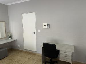a room with a desk with a chair and a door at Luxury and Comfort Hideaway 2 - Solar Powered in Pretoria