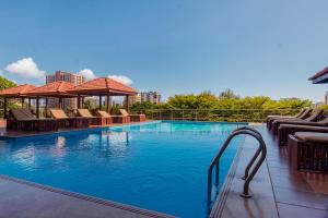 a large swimming pool with chairs and a gazebo at Aura Suites in Dar es Salaam