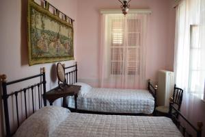 2 bedden in een slaapkamer met roze muren bij Oikia Ahanasia in Karlovasi