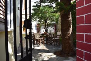 een patio met een tafel en stoelen en een boom bij Oikia Ahanasia in Karlovasi