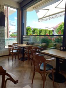 a restaurant with tables and chairs and a large window at Villa Jankuloski in Ohrid