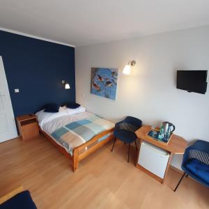 a bedroom with a bed and a desk and a tv at Villa REJS Jastarnia in Jastarnia