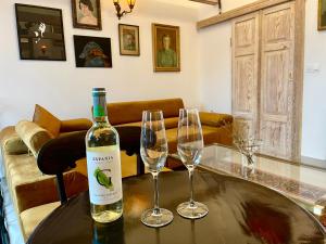 a bottle of wine and two wine glasses on a table at LOFT W RYNKU Z JACUZZI in Supraśl
