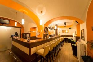 ein Restaurant mit einer Bar mit gelben und orangefarbenen Wänden in der Unterkunft Magnus Klause in Mariazell