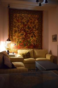 a living room with a couch and a large tapestry at Oikia Ahanasia in Karlovasi