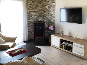 Bungalow Rudensicht في Freest: غرفة معيشة مع تلفزيون بشاشة مسطحة على الحائط