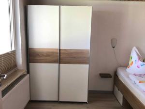 Bungalow Rudensicht في Freest: خزانة بيضاء كبيرة في غرفة نوم مع سرير +4 صور