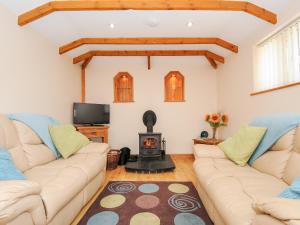 uma sala de estar com dois sofás e uma lareira em The Hideaway em St Austell