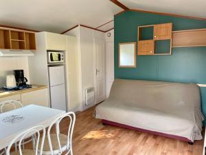 a small room with a bed and a kitchen at Camping Les Tourterelles in Rang-du-Fliers