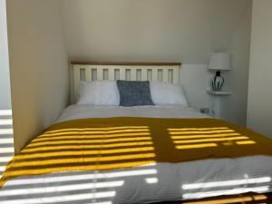 a bedroom with a bed with a yellow blanket on it at Weymouth Harbour Luxury Apartment in Weymouth