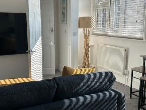 ウェイマスにあるWeymouth Harbour Luxury Apartmentのリビングルーム(青いソファ、ランプ付) +2枚の写真