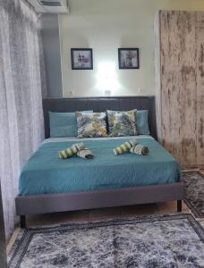 Una cama con sábanas azules y almohadas en un dormitorio en Athens Victoria's Apartment en Atenas