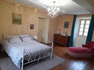 a bedroom with a bed and a chair and a chandelier at Maison de vacances au cœur des Pyrénées in Eysus