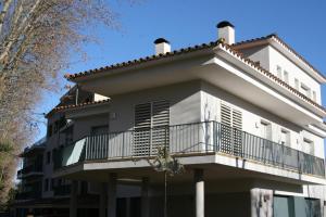 a white building with a balcony on a street at Apartament L'Ast in Banyoles