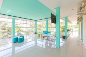 a room with a table and chairs and windows at Sans Hotel Borobudur Banyuwangi in Banyuwangi