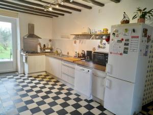 kuchnia z białymi urządzeniami i szachownicą w obiekcie Maison de vacances au cœur des Pyrénées w mieście Eysus