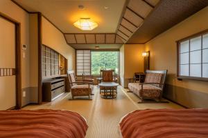 1 dormitorio con 2 camas, mesa y sillas en Jozankei Onsen Yurakusoan, en Jozankei