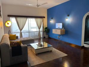 ein Wohnzimmer mit einem Sofa und einer blauen Wand in der Unterkunft Carel Holiday Homes in Mombasa