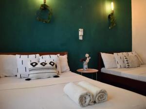 2 Betten in einem Zimmer mit grüner Wand in der Unterkunft Carel Holiday Homes in Mombasa