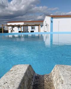 una piscina de agua azul frente a una casa en Summer Reference en Tavira