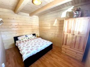 - une chambre avec un lit et un mur en bois dans l'établissement Ośrodek Nadmorska Perełka, à Rusinowo