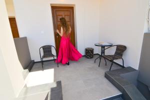 a woman in a red dress standing in a room at Elafonisi Paradise with Parking, WiFi, - Walking Distance to the Beach in Elafonisi
