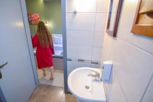 a woman in a bathroom looking at herself in the mirror at Elafonisi Paradise with Parking, WiFi, - Walking Distance to the Beach in Elafonisi