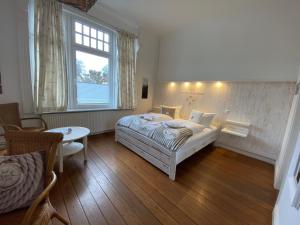 een slaapkamer met een bed, een tafel en een raam bij Villa Pension Strandhaus - adults only in Travemünde