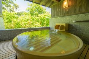 a bath tub with a water fountain in it at Jozankei Onsen Yurakusoan in Jozankei