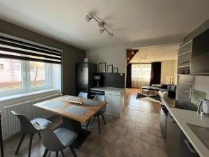 a kitchen and living room with a table and chairs at Guest house Jana in Muráň