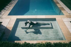a woman floating in a swimming pool at Château du Tertre in Arsac