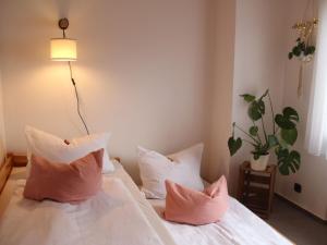 1 dormitorio con 1 cama con almohadas y lámpara en Große Wohnung mit Balkon Sulzbergblick in Alpirsbach, en Alpirsbach