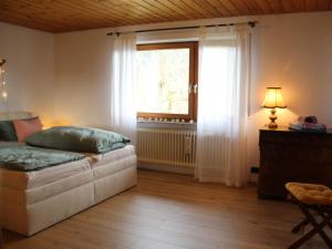 sala de estar con cama y ventana en Große Wohnung mit Balkon Sulzbergblick in Alpirsbach, en Alpirsbach