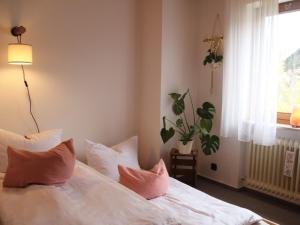 Un dormitorio con una cama blanca con almohadas y una ventana en Große Wohnung mit Balkon Sulzbergblick in Alpirsbach, en Alpirsbach