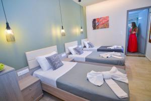 a room with two beds and a woman in a red dress at Elafonisi Paradise with Parking, WiFi, - Walking Distance to the Beach in Elafonisi