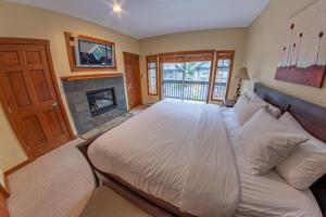 a bedroom with a large bed and a fireplace at Snowy Creek 04 - Ski In Ski Out, Private Hot Tub, Short Walk to Whistler Village in Whistler