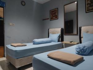 two beds sitting next to each other in a room at Pondok Seruni Kemanggisan Jakarta in Jakarta